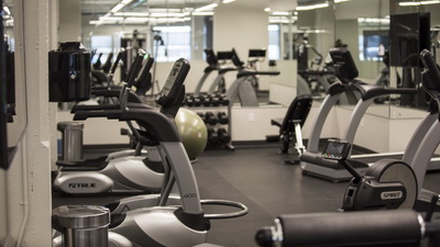 Fitness room that includes treadmills, elliptical machines, rowing machines, Peloton bikes and a multi-gym.