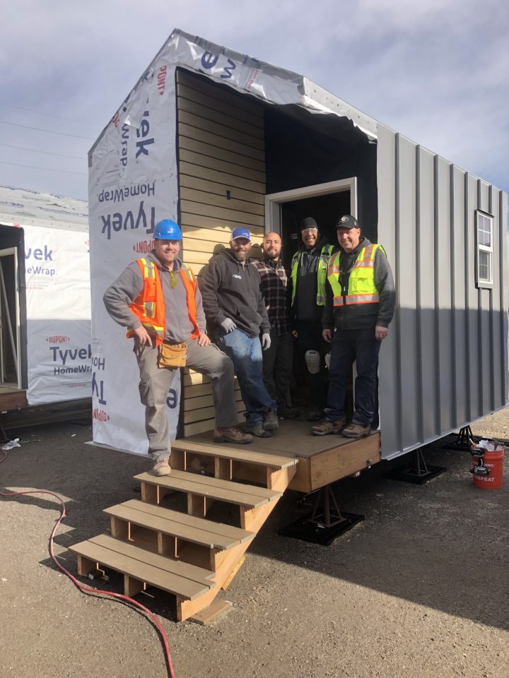 Colorado Doorways Account Manager Brian Phillips, Field Service Technicians Jeff Squillace, Carlos Mijares and Marcus Hall and Vice President of Operations Keith Rigli take a break from installing doors in new homes at Beloved Community Village.